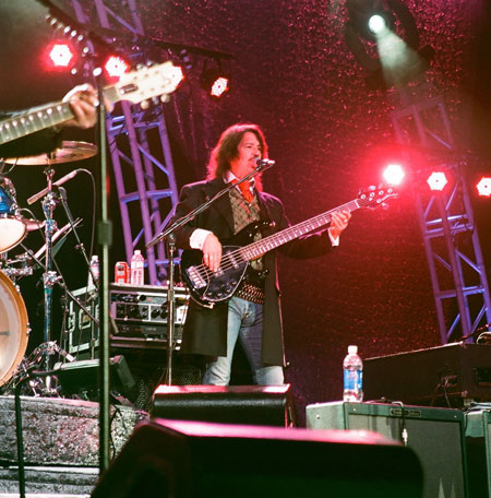 Kenny Loggins in concert with band members wearing Old Frontier Frock Coat